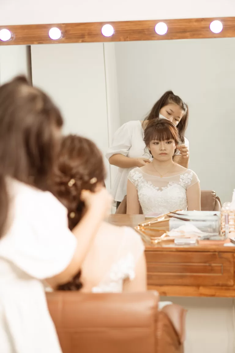 Behind the scenes of a bridal photoshoot. Aoi's Makeup is braiding the model's hair.